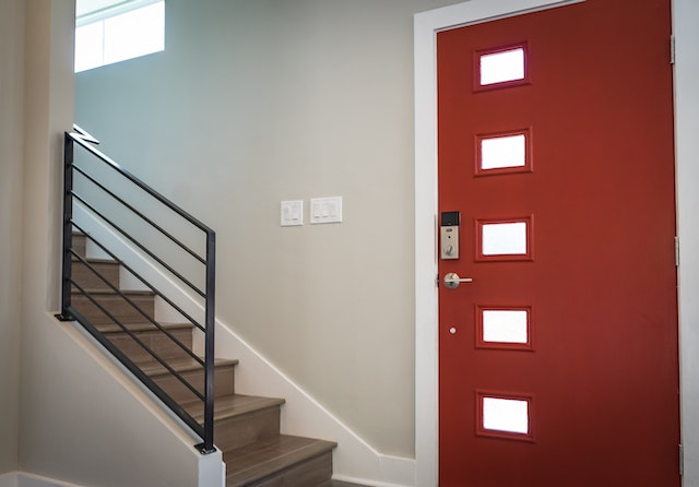 imagen del interior de una casa con una puerta roja que tiene un cerrojo de seguridad tras la desokupacion en jaen